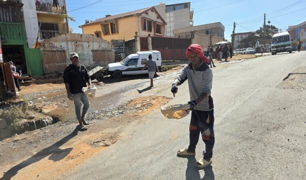 Do thiếu tiền công nên tình trạng đường sá ở Madagascar rất kém. Người Malagasy lấp một vài ổ gà bằng những phương tiện tạm bợ rồi nhờ những người lái xe ô tô đi ngang qua đóng góp. Ảnh EBRA /Luc Chaillot